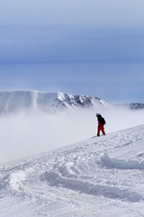 Fototapeta na wymiar Snowboarder on off-piste slope with newly fallen snow