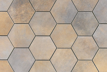 Beige-and-brown ceramic tile in the form of honeycombs. Hexagonal floor tiles.