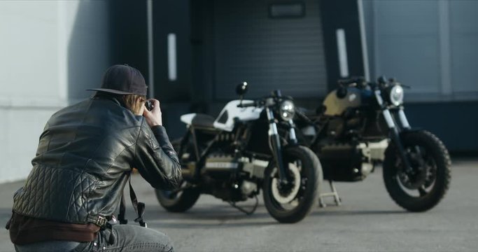 Photographer taking pictures of two custom built vintage cafe racer motorcycles in the street. 4K UHD RAW Graded footage