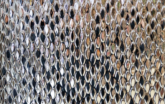 Metal panel with ornament in form fish scale. Background with volumetric metal pattern.