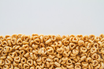 Row of whole grain oat cereal in a heart shape on a white background, top view, copy space. Heart shapes cereal. 