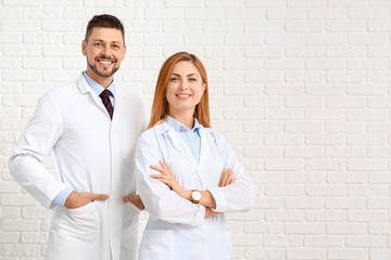 Team of doctors on white brick background