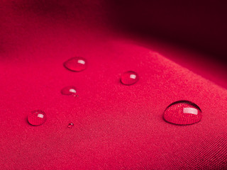 Purple waterproof fabric with water drops closeup