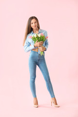 Beautiful young woman with flowers on color background. International Women's Day celebration