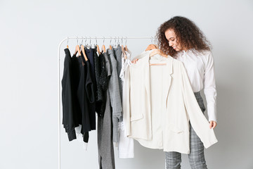 African-American stylist near rack with modern clothes