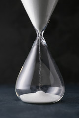 Hourglass on dark background. Time management concept