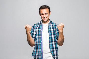 Fototapeta premium Young handsome man celebrating a victory on a white background