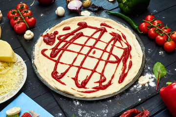 Cooking pizza. Raw pizza cakes and various ingredients for its manufacture.