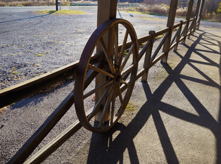 Wagon Wheel On Rustic Wooden Fence