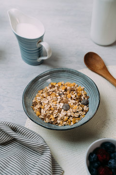 Bowl of granola with jug of yogurt in background