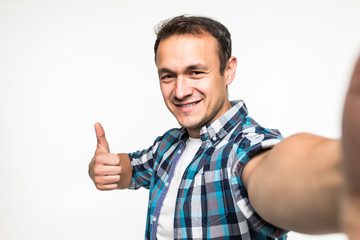 Fototapeta premium Happy man making selfie and showing thumb up isolated on white background