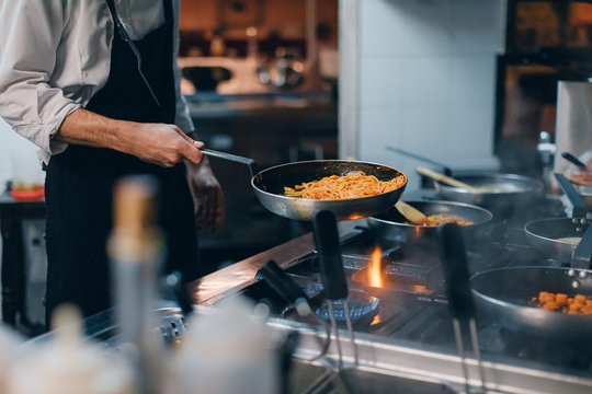 Chef Cooking Pasta In Italian Restaurant Kitchen