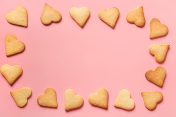 Border of homemade heart shaped cookies on pink. Flat lay.