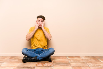 Young caucasian man sitting on the floor isolated whining and crying disconsolately.