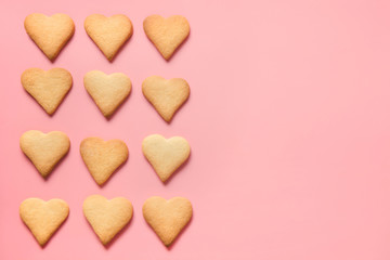 Border of homemade heart shaped cookies on pink. Flat lay.
