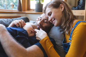 Affectionate family on the sofa with sleeping little son