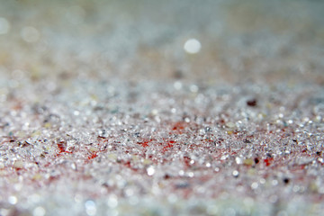 Artificial diamonds lying in the sand photographed in the studio with flash light