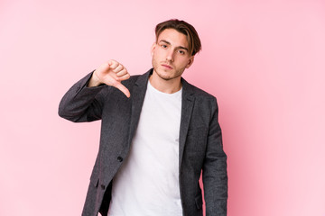 Young caucasian business man posing isolated showing a dislike gesture, thumbs down. Disagreement concept.