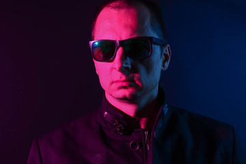 Obraz premium Fashion portrait of middle aged man elegant in sunglasses. Colored background, studio shot.