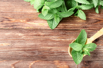 Mint leafs with spoon on brown wooden table