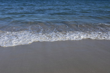Wasser mit Gischt am Strand