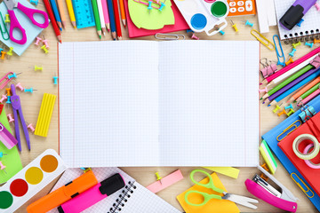 School supplies with blank sheet of paper on brown wooden table