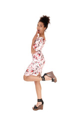 Happy multi-racial woman standing in a dress in profile