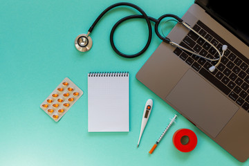 Doctor desk table with stethoscope and laptop computer. Top view with copy space, flat lay.