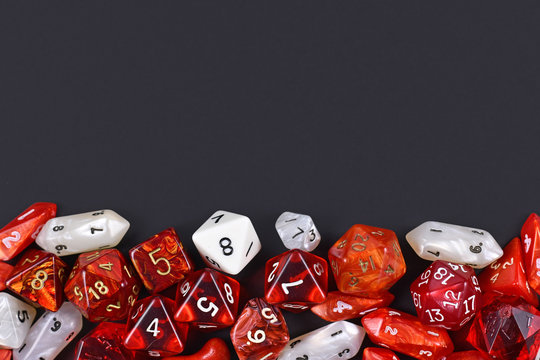 Background with different roleplaying RPG dice at bottom of dark black background with blank copy space