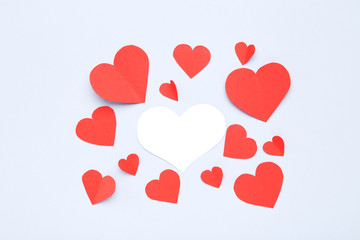 Red and white paper hearts on grey background