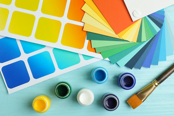 Flat lay composition with color palettes on light blue wooden background
