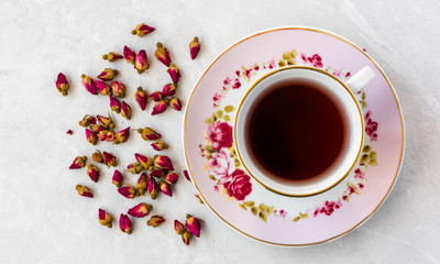 Top view of a cup of tea with dried roses 