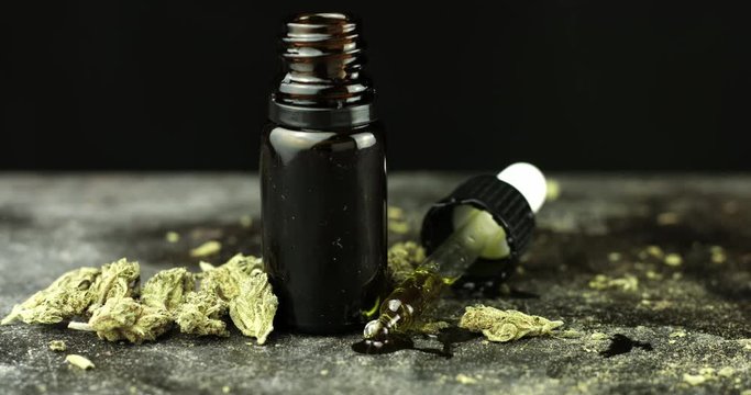 CBD Hemp oil in a droplet with Cannabis Buds. Alternative Medicine. 4k Pan, Slow Motion