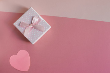 Gift box with ribbon and heart for Valentine's Day on pastel color background.  Love and  present concept.