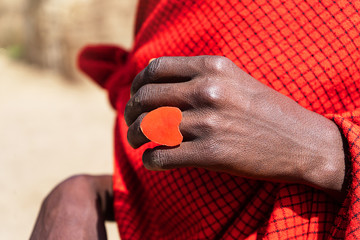 African man holding a smoldering cake in his hands with a red heart ring.