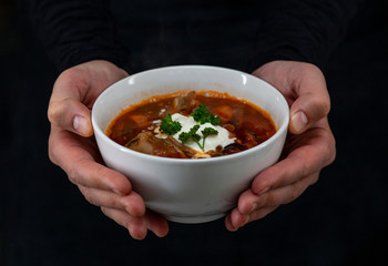 borsch in a white plate, beetroot soup with sour cream and parsley