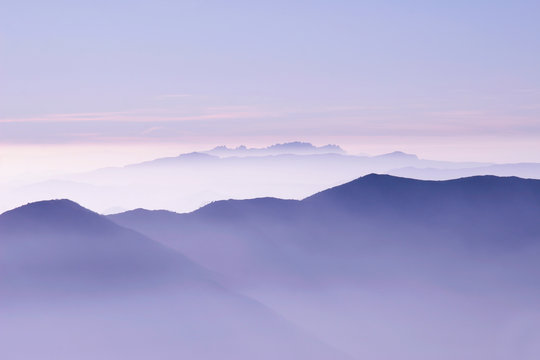 skyline of purple mountains in a misty dawn morning