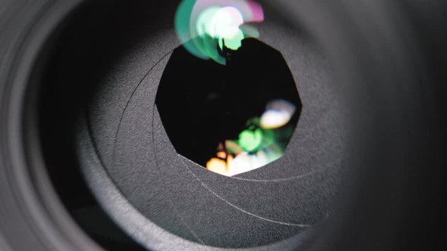 Camera lens aperture close-up. Aperture blades opening and closing during shooting