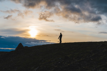 silhouette of man on top of mountain