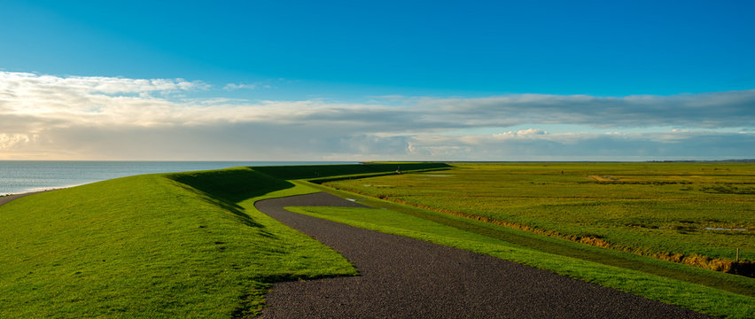  typical Dutch meandere dike with cycle path and view of the Wadden Sea