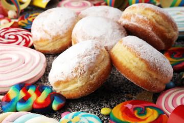Carnival powdered sugar raised donuts with paper streamers. German berliner or krapfen for carnival