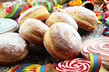 Carnival powdered sugar raised donuts with paper streamers. German berliner or krapfen for carnival