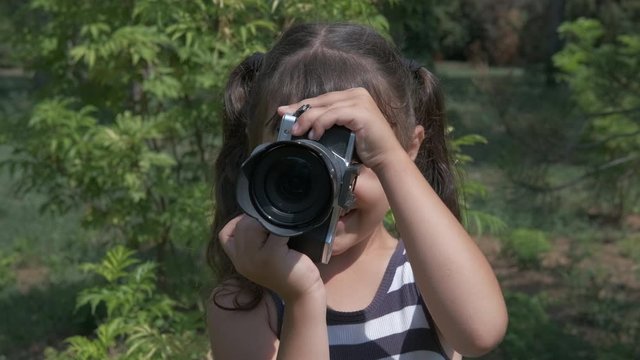 Kid play with camera in nature.