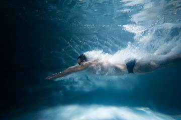 Fototapeta na wymiar professional swimmer underwater after the jump