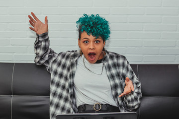 afro american girl looking at laptop with surprise or astonishment