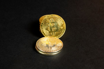 Shiny stack bitcoin coins on black textured background, close up view