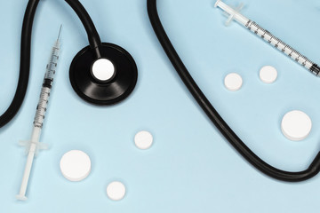 Stethoscope, pills and syringes, attributes medical,health care ,cardiac care on above blue background