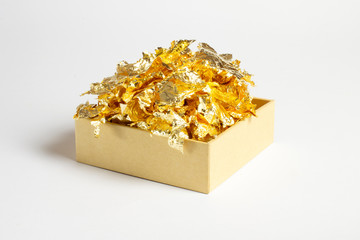 Cardboard gift box with decorative gold foil pieces isolated on white background with soft shadow, can be used for text on sides, backgrounds, compositions etc.