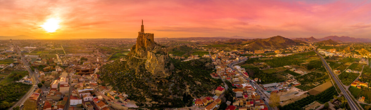 Monteagudo medieval castle ruin twelve rectangular towers circling the hilltop and the sacred heart of Jesus Christ statue on top near Murcia Spain