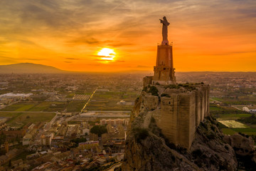Monteagudo medieval castle ruin twelve rectangular towers circling the hilltop and the sacred heart of Jesus Christ statue on top near Murcia Spain